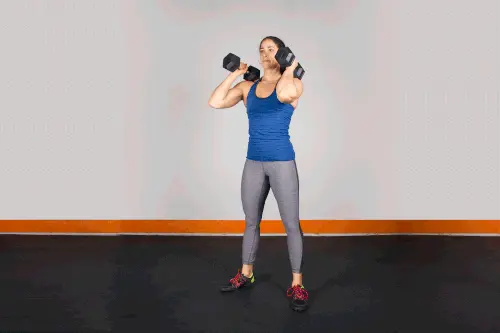 زن ورزشکار در حال اجرای اسکوات با دمبل برای تقویت پا و باسن در برنامه تمرین ترکیبی بانوان