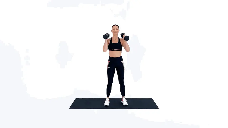 زن ورزشکار در حال انجام حرکت ترکیبی اسکوات و پرس شانه برای چربیسوزی کل بدن