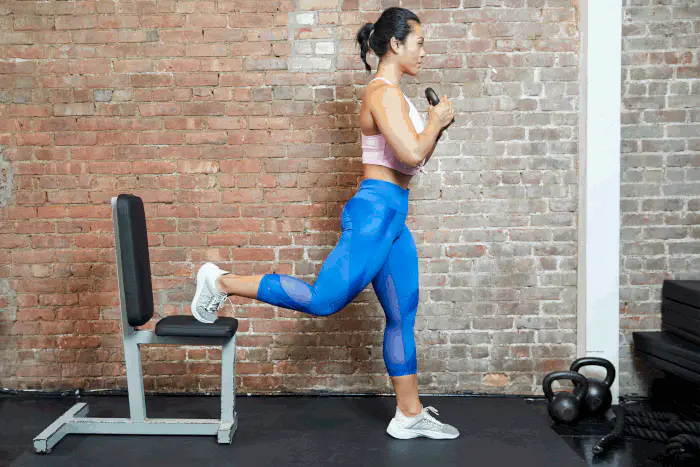 حرکت اسپلیت اسکوات بلغاری بدون وزنه توسط بانوی ورزشکار برای عضلهسازی باسن و ران